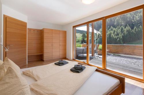two beds in a room with a large window at Pritscheshof Ferienwohnung Terrasse in Malles Venosta