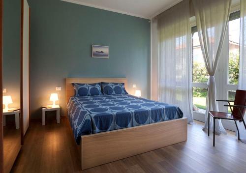 a bedroom with a blue bed and a window at Maison Rouge in Besnate