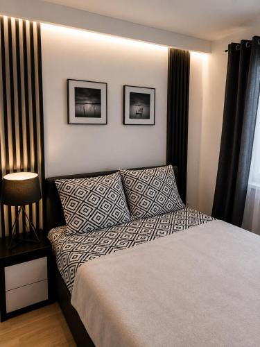 a bedroom with a bed and two pictures on the wall at Apartamenty Royal in Bartoszyce