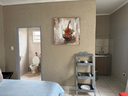 a bedroom with a bed and a painting on the wall at Nkandla Yethu Guest House in Nelspruit