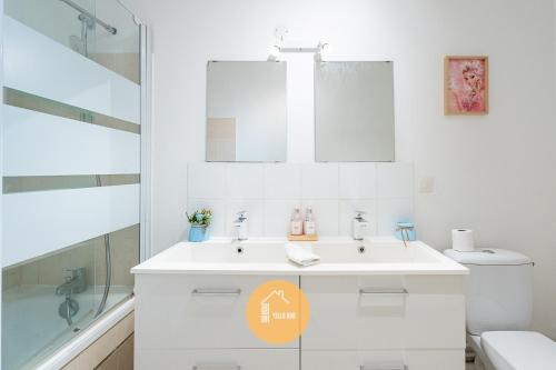 a white bathroom with a sink and a toilet at Duplex Le G - Reine des neiges 10 min Disney Paris in Montévrain