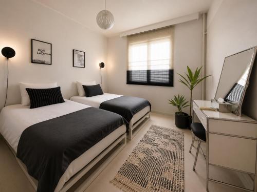 a bedroom with two beds and a desk and a window at Yoonsul Gwangalli 3beds for 4guests in Suyŏng