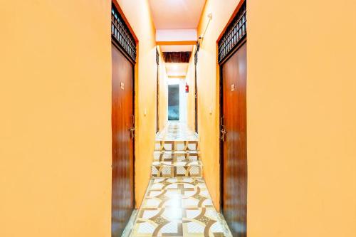 a corridor of a hallway with orange walls and wooden doors at HOTEL O SUNSHINE in Ghaziabad