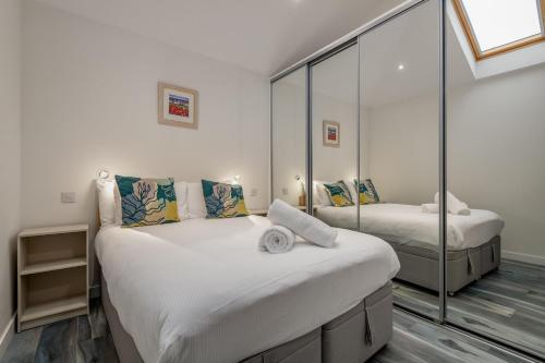 a bedroom with two beds and a mirror at Tylosand, Allan Place No 8 in Earlsferry