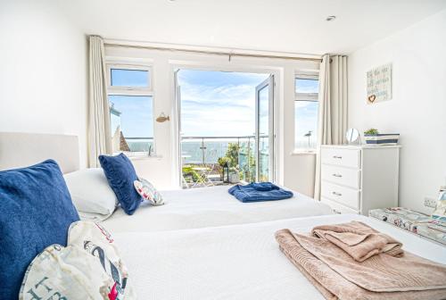 a bedroom with a bed with a view of the ocean at Jan Dee Cottage in Ventnor