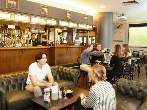 a group of people sitting in a bar at Novotel Perth Langley in Perth