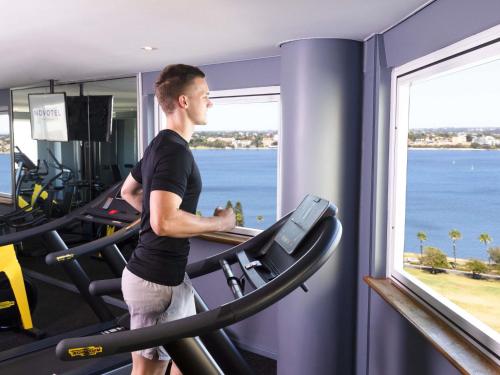 a man running on a treadmill in a gym at Novotel Perth Langley in Perth