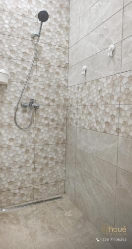 a bathroom with a shower with a glass door at Résidence Houé in Lomé