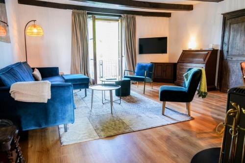 a living room with blue furniture and a tv at Maison Ainvelle - with Sauna in Ainvelle