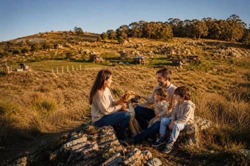 a family sitting on a rock with a dog at Valle de la Luna in Tandil