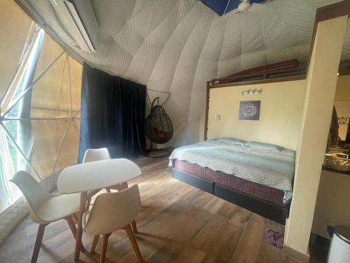 a bedroom with a bed and a table and chairs at Private Dome Relax in Nature in San Bernardino