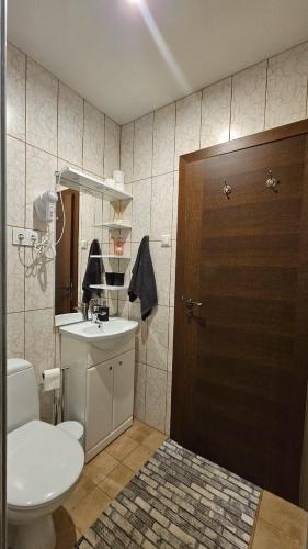 a bathroom with a toilet and a sink and a door at ''Ābeļdārzs'' in Jelgava