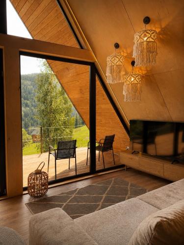 a living room with a large window and a bed and chairs at Dilok Hills in Mykulychyn