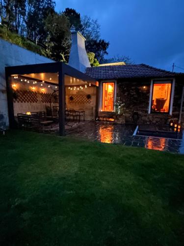 a house with a lit up backyard at night at Casinha Serabigoes Arouca Passadiços Paiva in Arouca