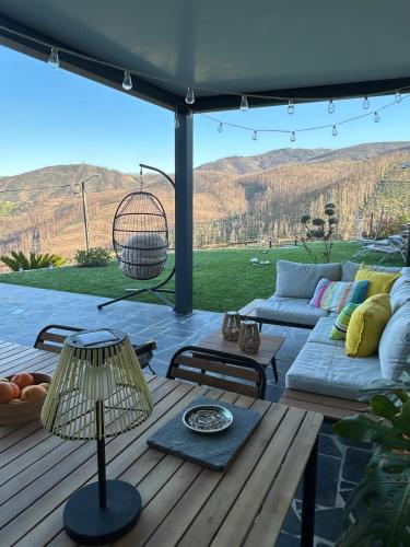 a patio with a couch and a table at Casinha Serabigoes Arouca Passadiços Paiva in Arouca