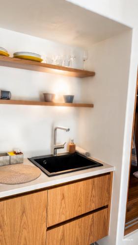 a kitchen with a sink and wooden cabinets at Porto Paradiso Seaside Resort in Vromolimnos