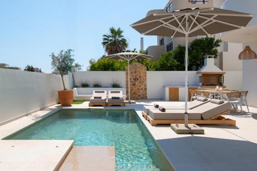 a swimming pool with lounge chairs and an umbrella at Villa Rhodea in Ialysos