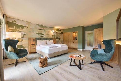 a hotel room with a bed and two chairs at Dorint Sporthotel Garmisch-Partenkirchen in Garmisch-Partenkirchen