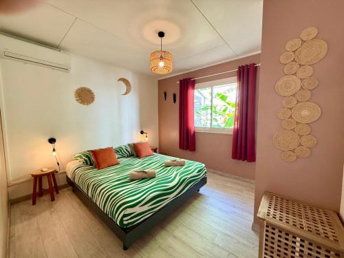 a bedroom with a bed and a window at Bungalow Tec-Tec Proche plage et centre Saint Leu in Saint-Leu