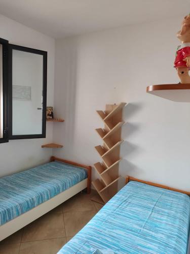 a room with two beds and a window and a staircase at Villa Cristina in Triscina