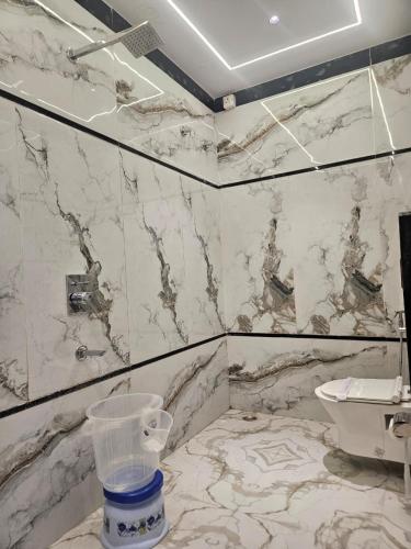 a bathroom with a white marble wall with a sink at Hotel Prabhawati Palace Near Railway Station and Sri Vishwanath Temple Varanasi in Varanasi
