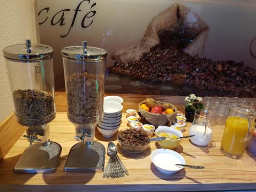 a table with two containers of food and a pile of fruit at Pension Schweizer Hof in Wernigerode