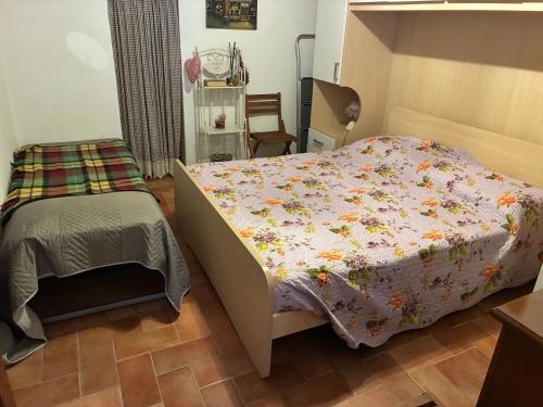 a bedroom with a bed with a flowered blanket at La Tua Casina in Torrenieri