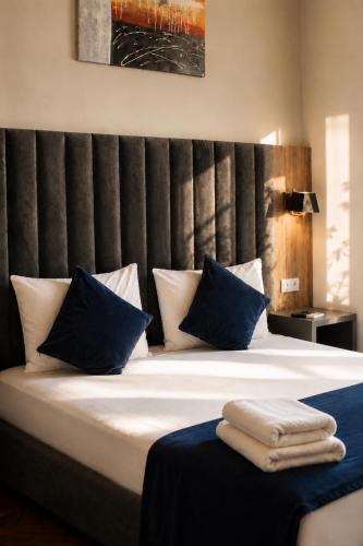 a bedroom with a large bed with blue pillows at BS Studios in Baku