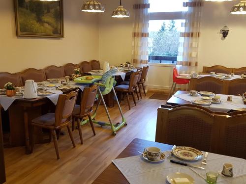 a dining room with long tables and chairs at Pension Schweizer Hof in Wernigerode