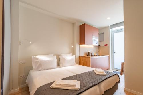a bedroom with a bed with two towels on it at Studio FAMEUSE in Matosinhos