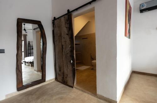 a hallway with a large mirror and a bedroom at Faro Resort in Nungwi