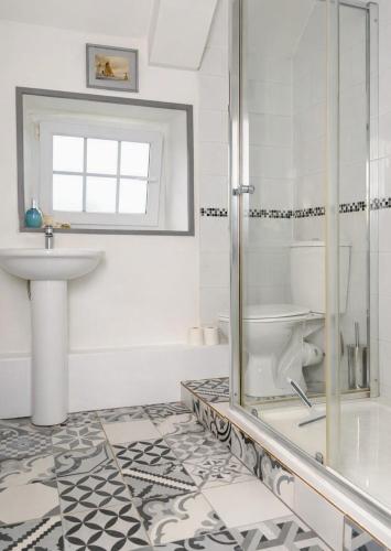 a white bathroom with a shower and a sink at Le Gîte des Violettes in Ger