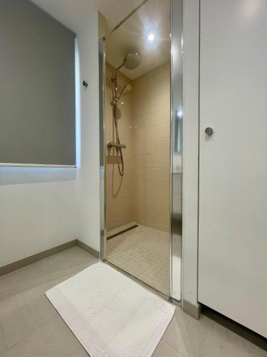 a shower stall with a glass door in a bathroom at La Maison Caroline in Surbourg