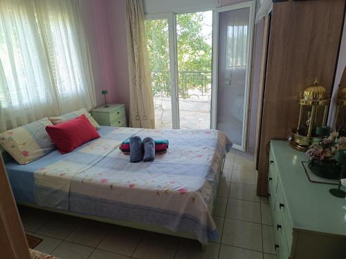 a bedroom with a bed with two shoes on it at Dimis apartments in Leptokarya