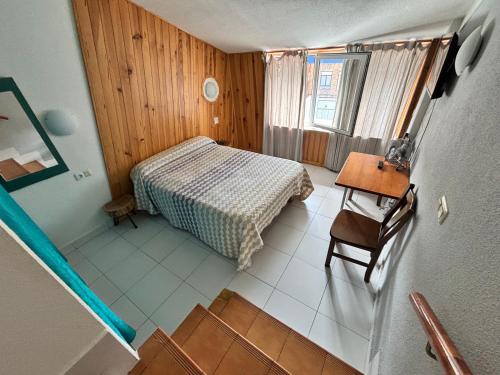 una pequeña habitación con una cama y una mesa en Hotel Viar, en Cabezón de la Sal