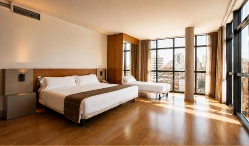 a hotel room with a bed and a large window at Vértice Indalo Almería in Almería