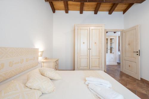 a bedroom with a large white bed with two pillows at Agriturismo Cirra in Tertenìa