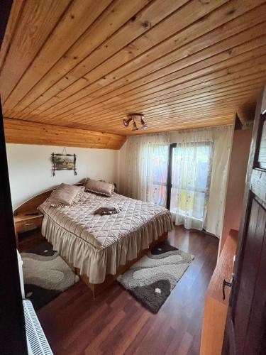 a bedroom with a large bed with a wooden ceiling at Vacation home E in Borsec