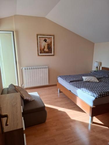 a bedroom with a bed and a couch at More in Rab