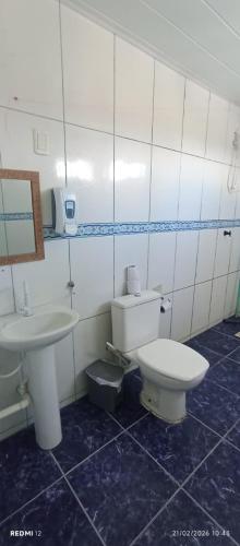 a bathroom with a toilet and a sink at Hostel Canarios in Palhoça
