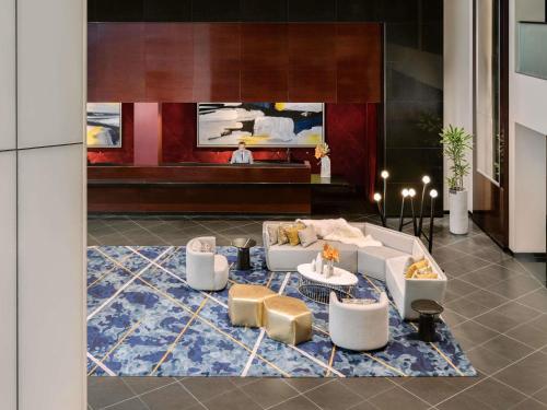 a living room with white couches and a blue rug at Sofitel Chicago Magnificent Mile in Chicago