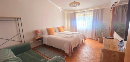 a bedroom with a bed with orange pillows at Casas do Monte I - T3 