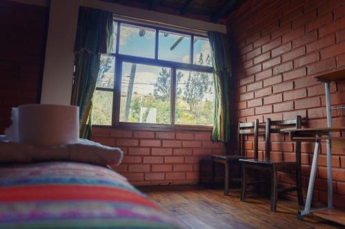a room with a brick wall and a window at PatulomaEscape in El Rosario