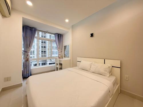 a bedroom with a white bed and a window at StayX Sky Garden in Ba Ria