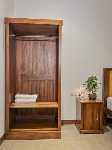 a wooden closet with a wooden door in a room at Grandpa's villa Jaffna in Jaffna