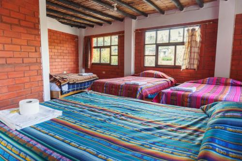 a room with two beds and a brick wall at PatulomaEscape in El Rosario