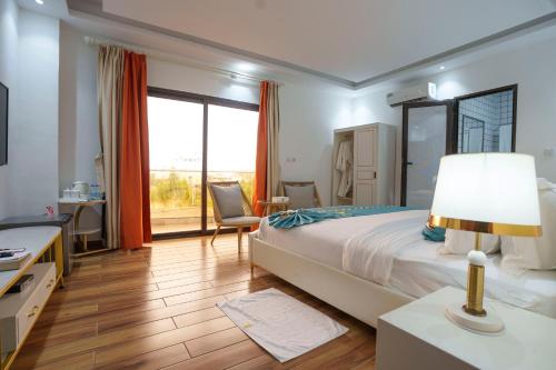 a bedroom with a large bed and a large window at Cinq Cent Vingt Hotel & Residence in Abidjan