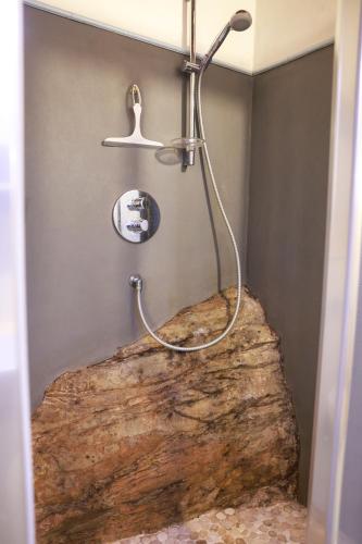 a shower in a bathroom with a large log at The River House in Bagnone
