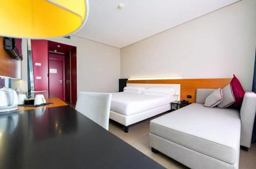 a room with two beds and a table and a couch at Cosmopolitan Hotel in Civitanova Marche