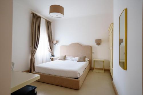a bedroom with a white bed and a mirror at Villa Natia in Mottola